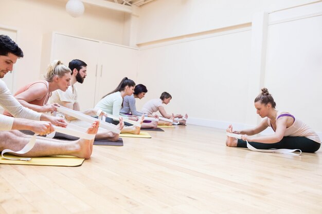 Treinador grupo de pessoas ajudando com exercício de alongamento