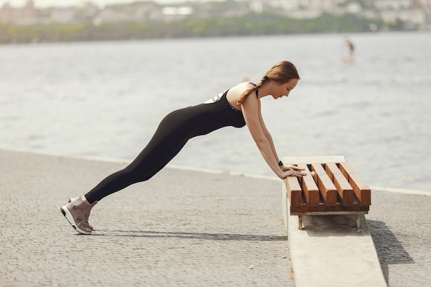 Treinamento de linda garota. garota de esportes em um sportswear. mulher perto da água.