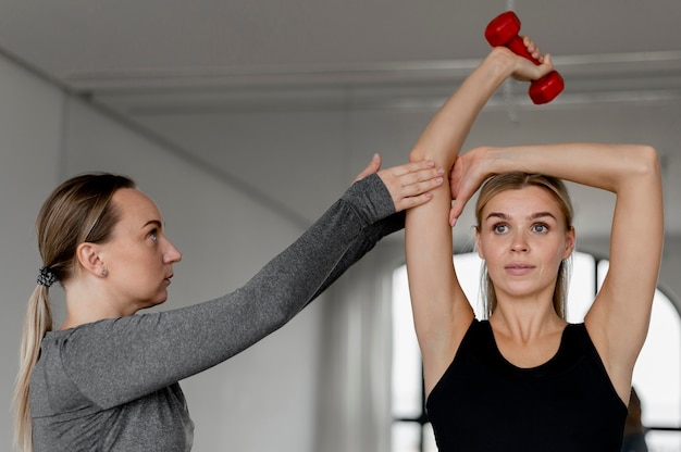 Foto grátis treino com personal trainer e halteres