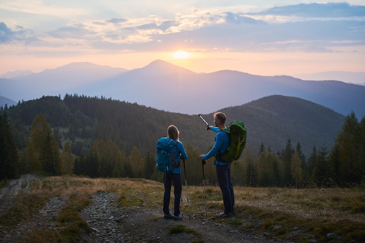 Foto grátis trekking de montanha de verão dois viajantes caminhando nas montanhas