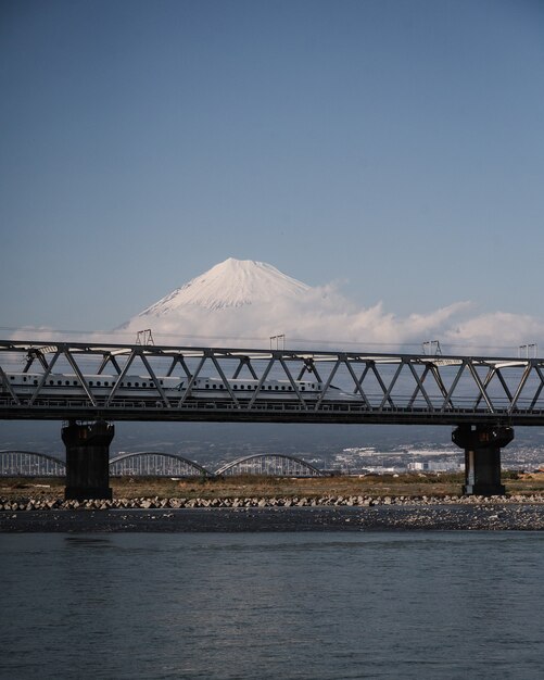 Trem Shinkansen de alta velocidade sobre o rio Fuji com uma montanha Fuji fascinante