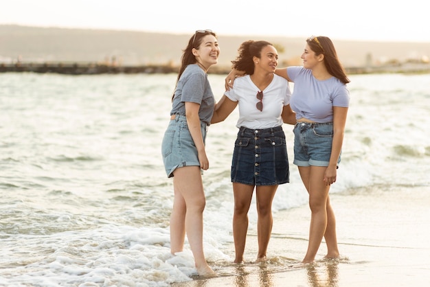 Foto grátis três amigas juntas na praia