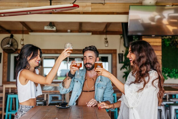 Três amigos brindando com cerveja