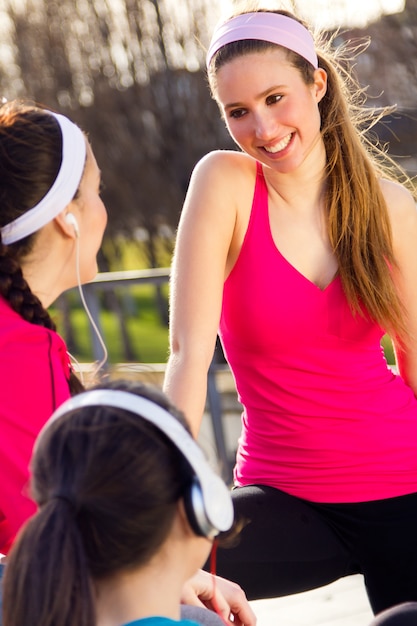 Três amigos com roupas esportivas falando depois do exercício