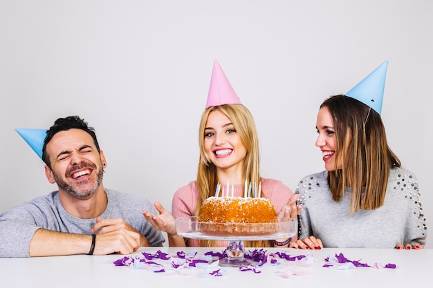 Três amigos felizes comemorando aniversário