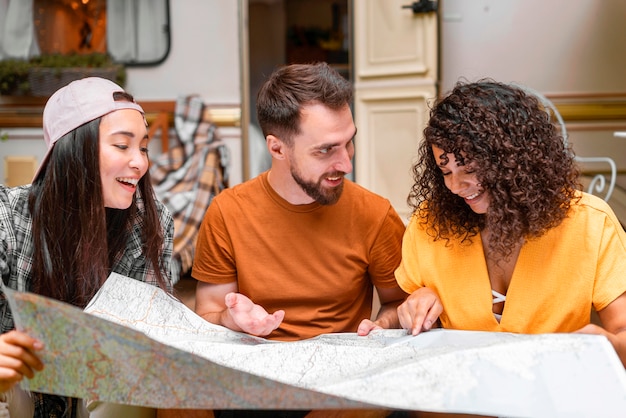 Três amigos felizes olhando para um mapa