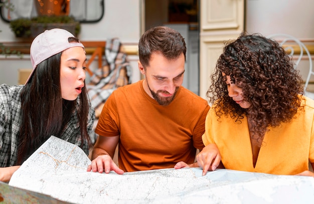 Foto grátis três amigos felizes usando um mapa