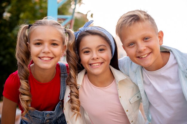 Três amigos fofos sorrindo no playground