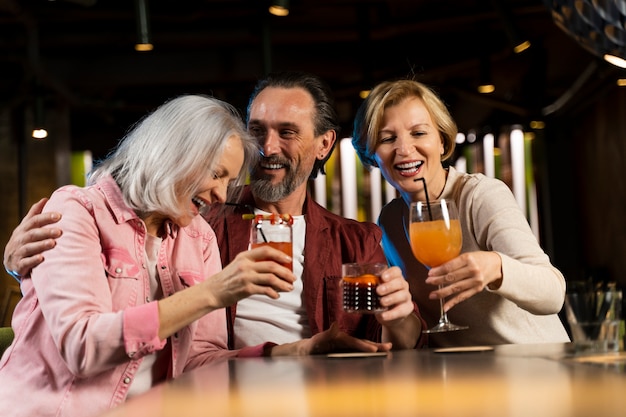 Três amigos mais velhos bebendo em um restaurante