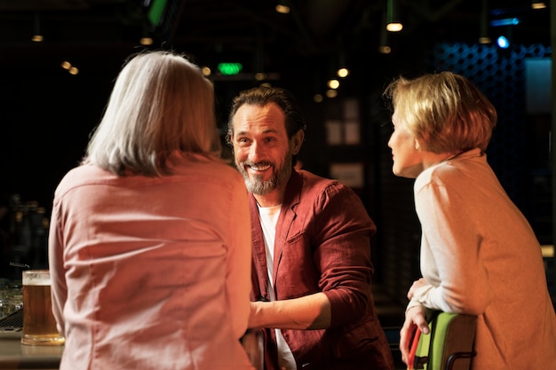 Foto grátis três amigos mais velhos conversando em um restaurante