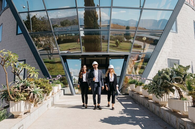 Foto grátis três arquitetos em frente ao edifício moderno