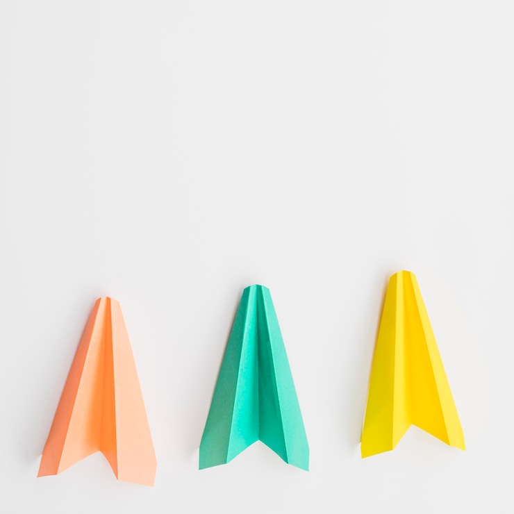 Foto grátis três aviões de papel colorido em linha