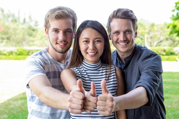 Três, bem sucedido, estudante, amigos, mostrando, polegares, cima