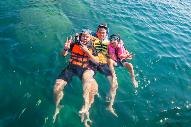 Três caras flutuando alegremente na água do mar
