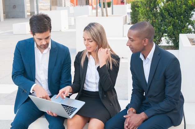 Três colegas de trabalho assistindo a apresentação