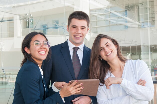 Três, colegas, em, corredor, olhando câmera, sorrindo