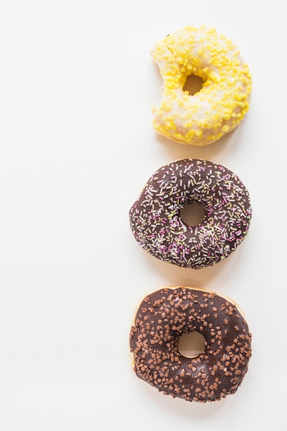 Foto grátis três donuts diferentes no fundo branco