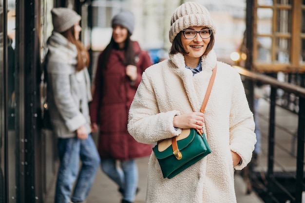 Três estudantes com roupa de inverno na rua