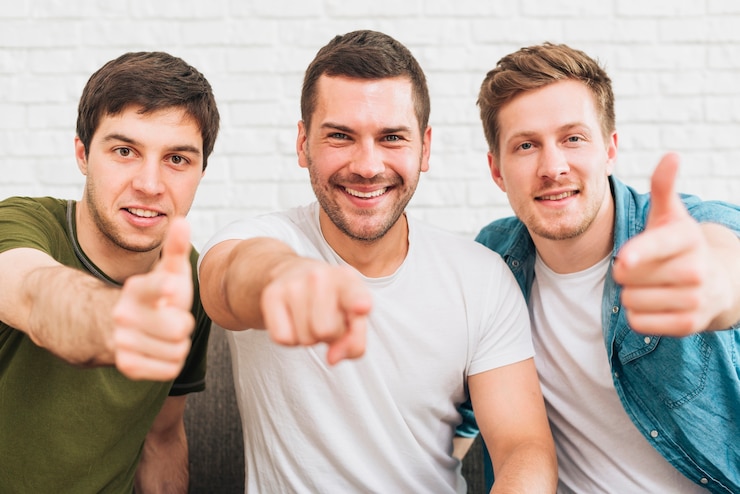 Foto grátis três, feliz, macho, amigos, apontar, dedo, direção, câmera