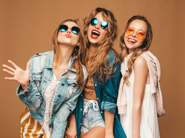 Três jovens lindas meninas sorridentes em roupas casuais na moda verão. Mulheres sexy despreocupadas posando. Modelos positivos
