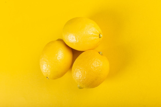 Foto grátis três limões brilhantes frescos em amarelo