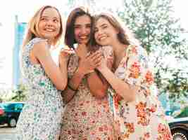 Foto grátis três lindas meninas sorridentes no vestido de verão na moda posando na rua