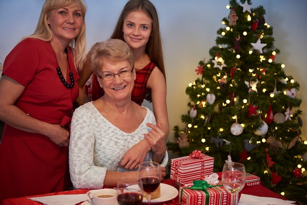 Três mulheres ao lado da árvore de natal