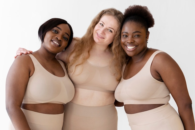 Três mulheres confiantes posando usando um modelador de corpo