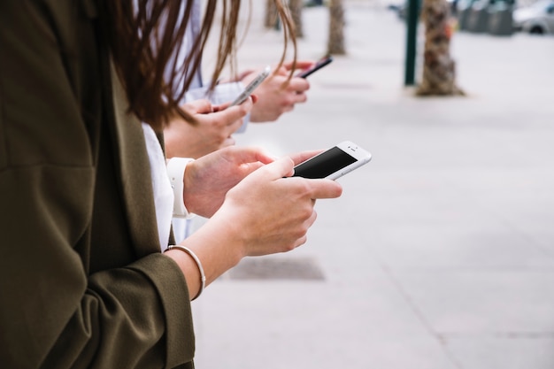 Três pessoas, usando, telefone pilha, ao ar livre