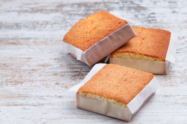 Três sobaos pasiegos em uma velha mesa de madeira vista de lado