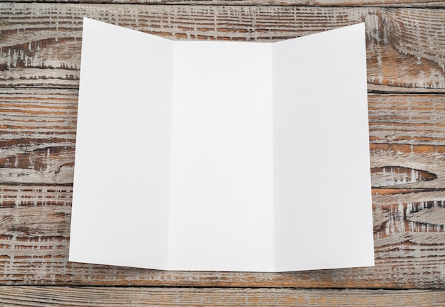 Foto grátis trifold papel modelo branco na textura de madeira.