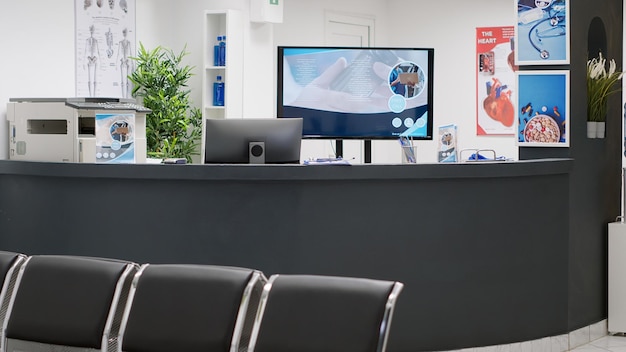 Átrio da sala de espera com balcão de recepção vazio para atendimento e apoio aos pacientes com marcação de consultas. Espaço de tratamento profissional com consultas de check-up e exame clínico.