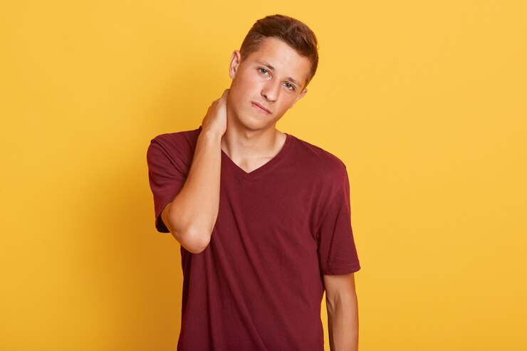 Foto grátis triste homem bonito sente cama, com dor no pescoço