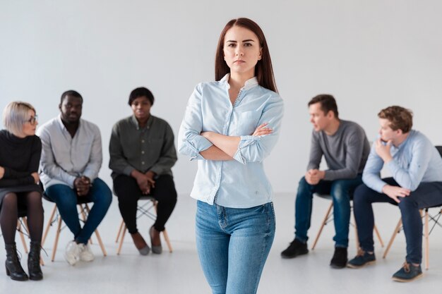 Triste mulher em pé na frente de pacientes de reabilitação