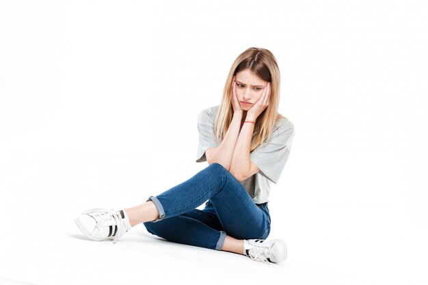 Triste mulher sentada de pernas cruzadas