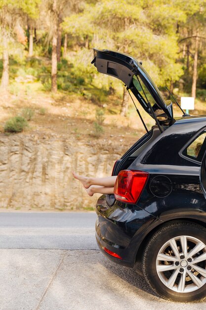 Tronco aberto de carro com pernas de mulheres