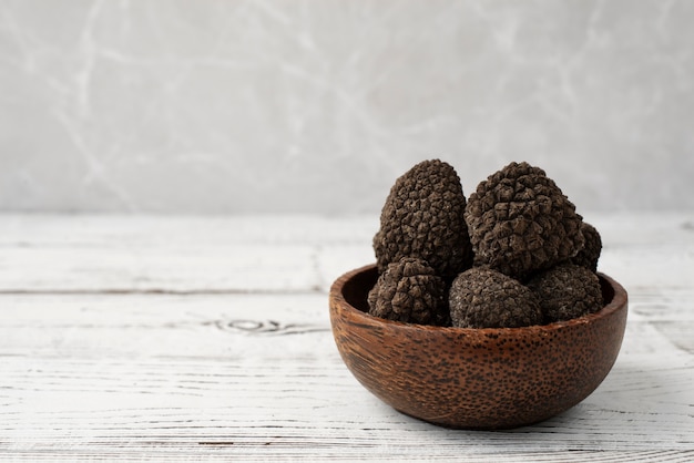 Trufas cruas em tigela na mesa de madeira