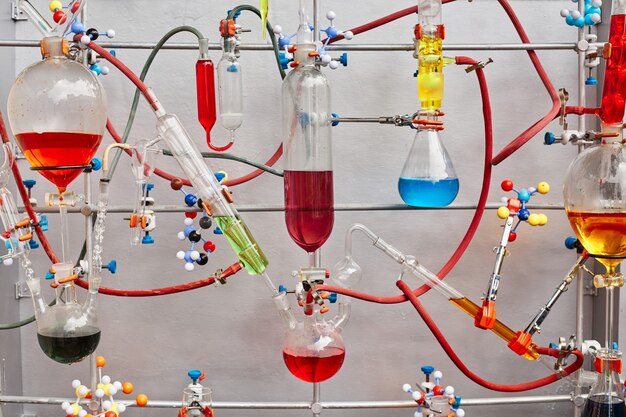 Tubos de ensaio de vidro com líquido viscoso colorido isolados sobre superfície cinza em laboratório químico