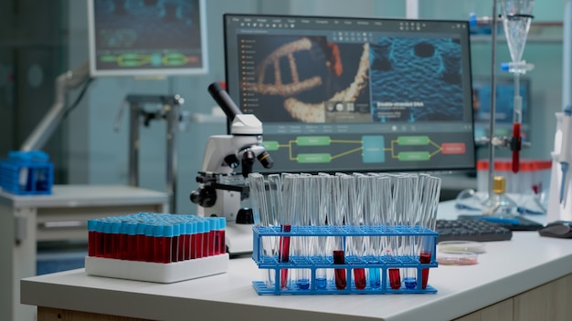 Tubos de ensaio médico com sangue na mesa do laboratório