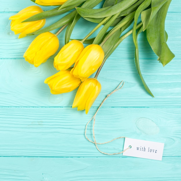 Foto grátis tulipas amarelas e com inscrição de amor na mesa