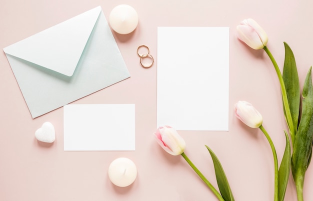 Foto grátis tulipas ao lado de anéis de noivado e cartão de convite