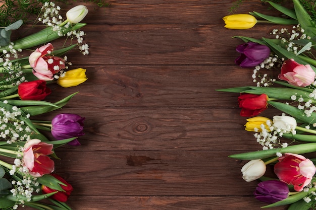 Foto grátis tulipas coloridas e flor de respiração do bebê na mesa de madeira texturizada