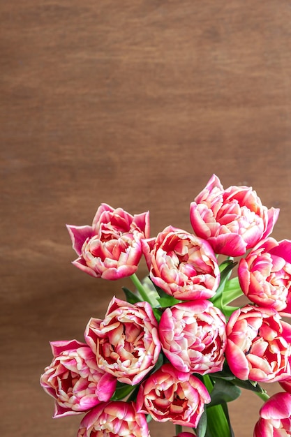 Tulipas frescas cor-de-rosa em uma mesa de madeira