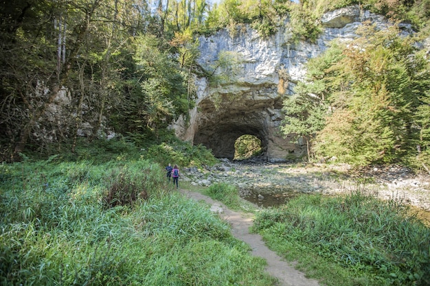 Túnel através de uma parede de rocha em um parque natural em Rakov Skocjan, Eslovênia