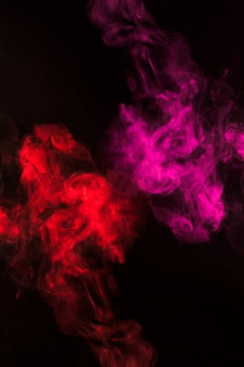 Turbilhão de fumaça vermelha e rosa em fundo preto