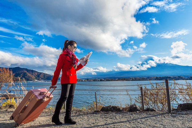 Turista com bagagem e mapa na montanha fuji, kawaguchiko, no japão.