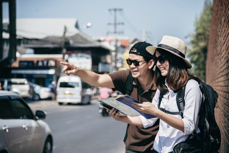 Foto grátis turista de casal asiático segurando o mapa da cidade