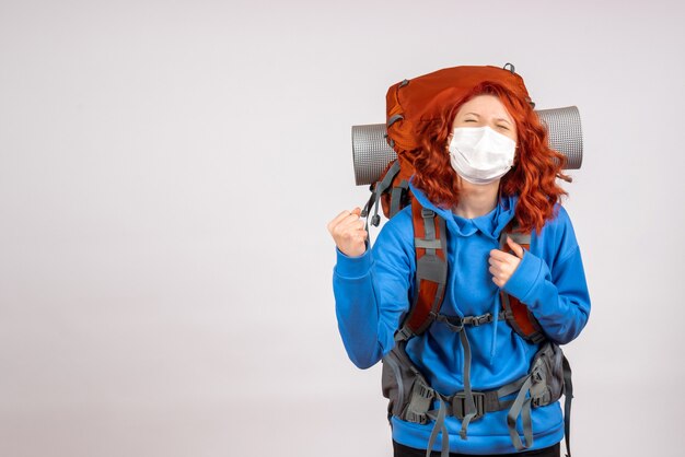 Turista de frente para uma viagem na montanha com máscara e mochila