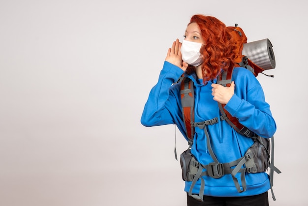 Turista de frente para uma viagem na montanha com máscara e mochila