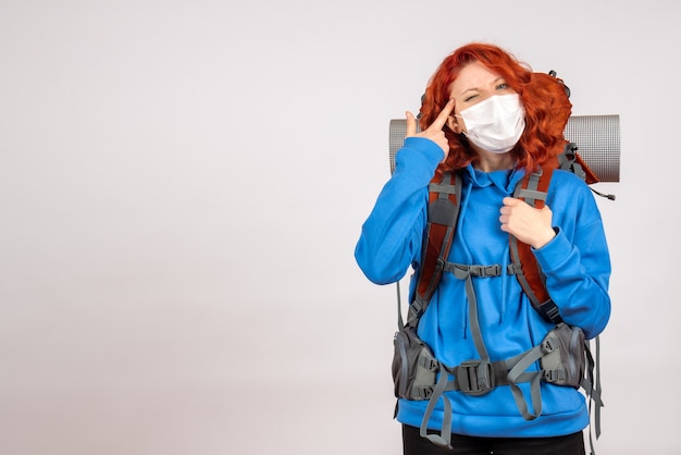 Foto grátis turista de frente para uma viagem na montanha com máscara e mochila